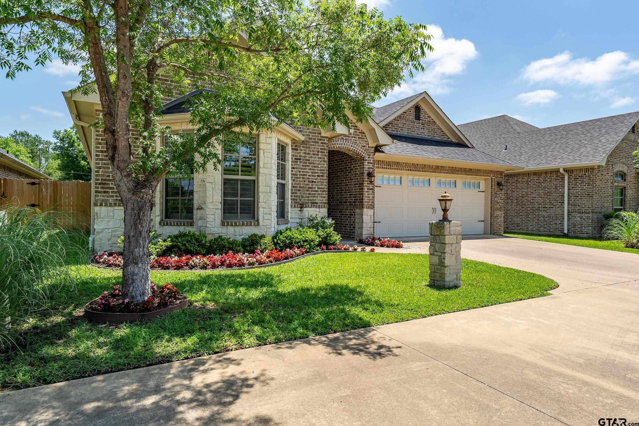 5524 Hollytree Drive Tyler, TX 75703 - Photo 2 of 27 a front view of house with garden and trees
