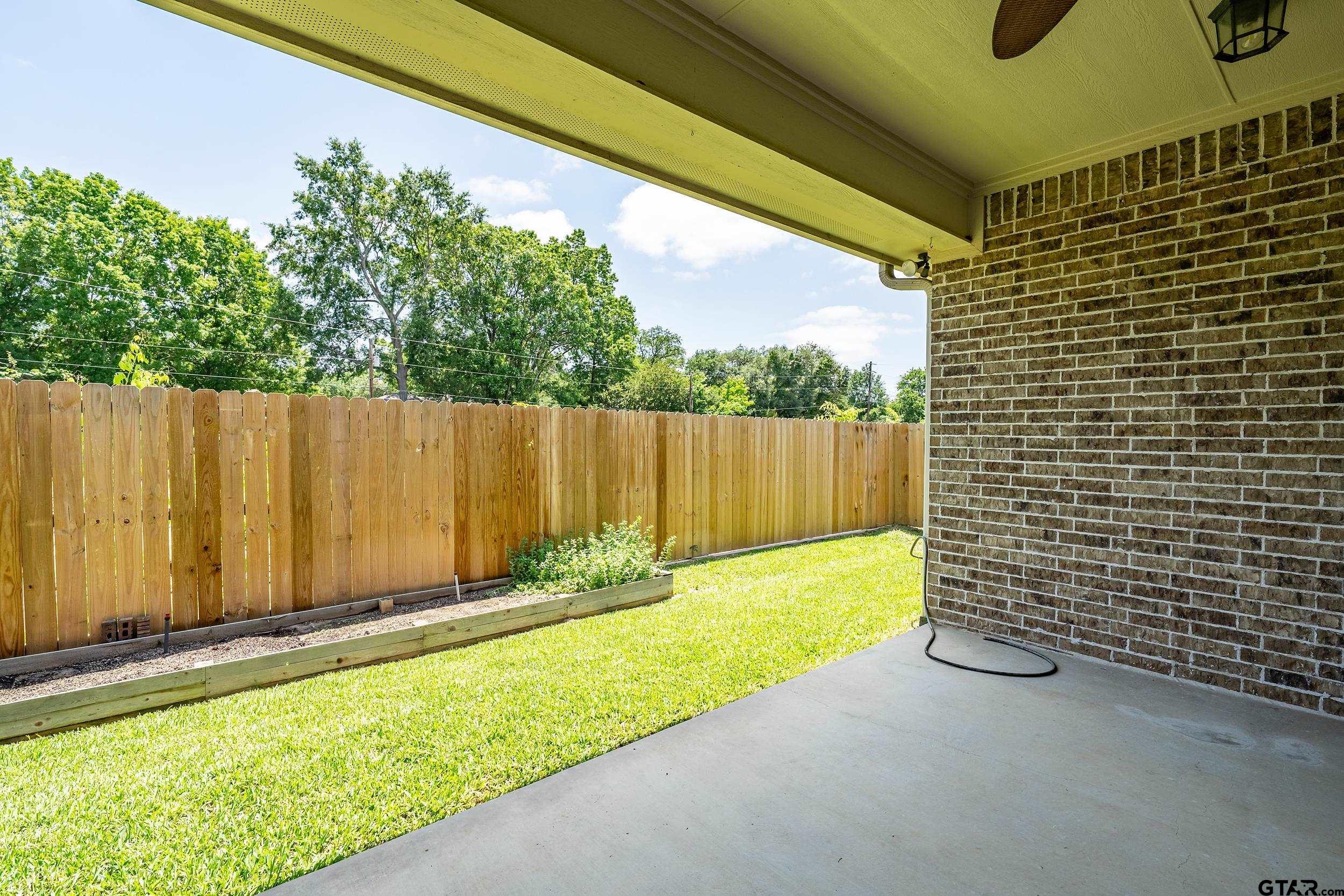 5524 Hollytree Drive Tyler, TX 75703 - Photo 25 of 27 a view of a backyard with a small cabin