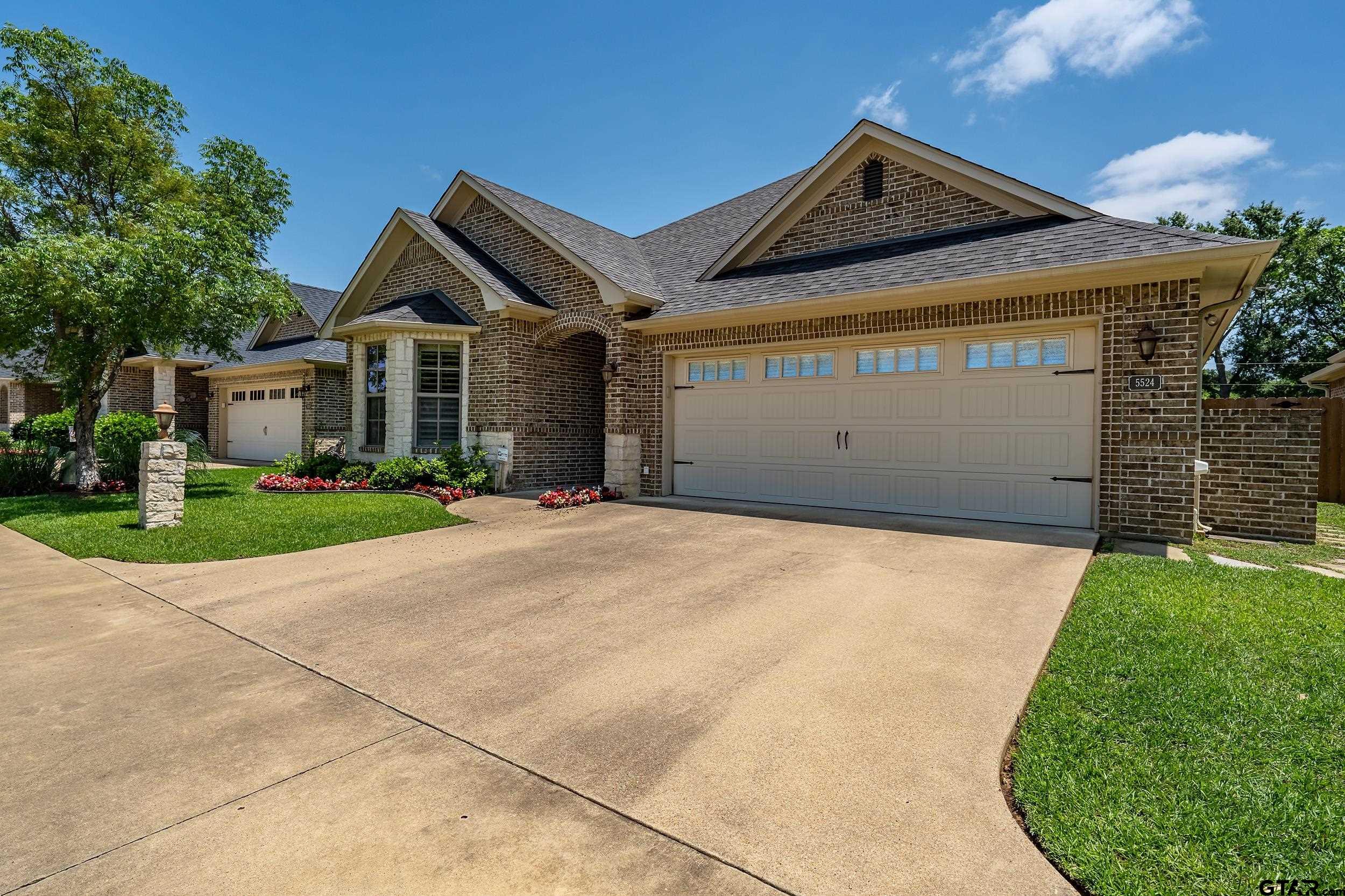 5524 Hollytree Drive Tyler, TX 75703 - Photo 3 of 27 a front view of a house with a garden and plants