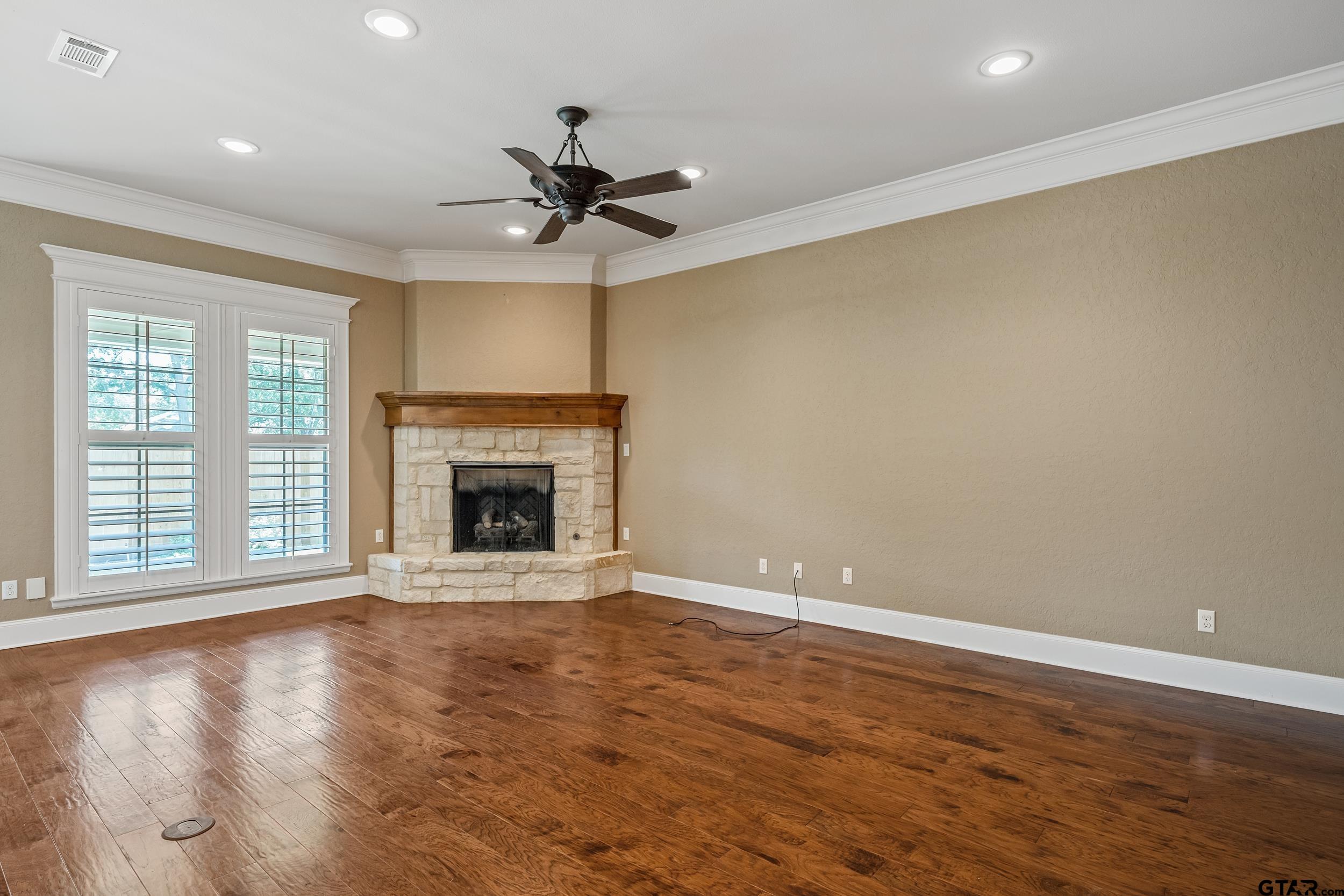 5524 Hollytree Drive Tyler, TX 75703 - Photo 6 of 27 a view of an empty room with a fireplace and a window