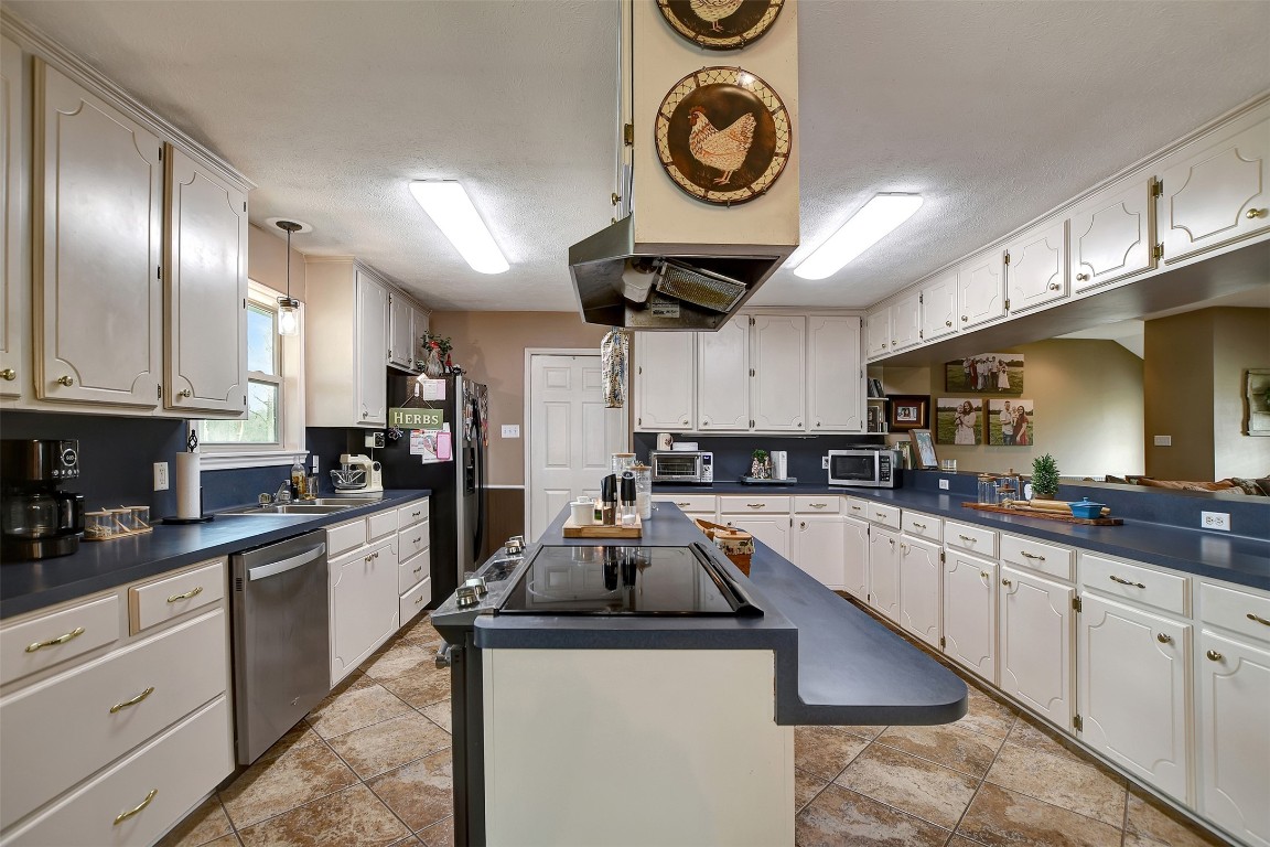 599 County Road 295 Garrison, TX 75946 - Photo 13 of 50 a kitchen with kitchen island granite countertop cabinets a stove a sink and a oven