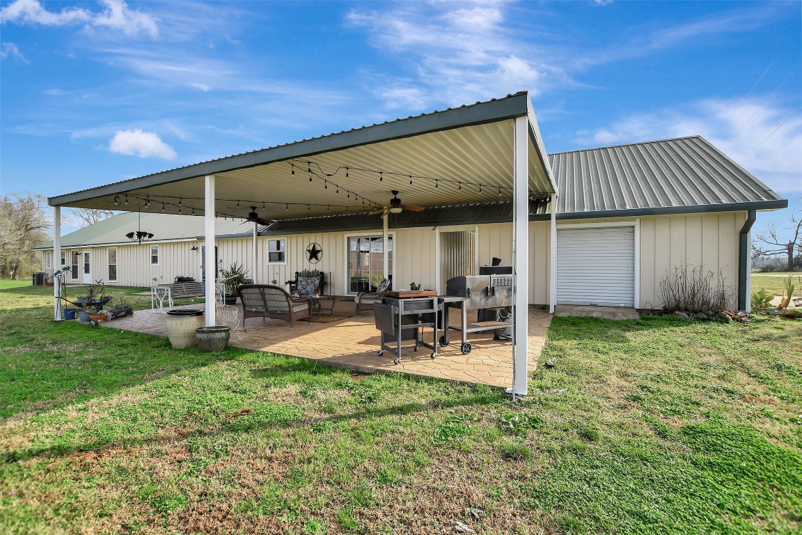 599 County Road 295 Garrison, TX 75946 - Photo 36 of 50 a view of a backyard with table and chairs under an umbrella with wooden fence