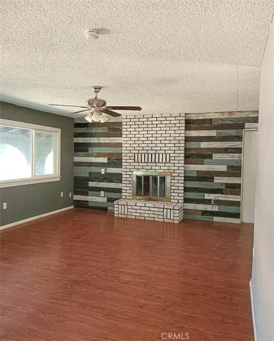 a view of an empty room with a fireplace and a window