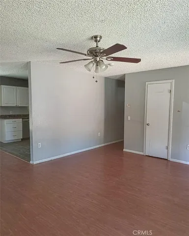 a view of a room with an empty space and a ceiling fan