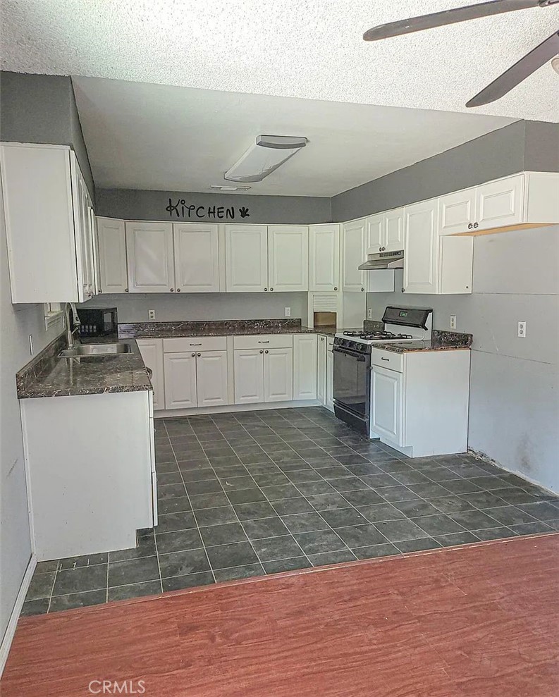 23080 Clement Street Red Bluff, CA 96080 - Photo 7 of 11 a kitchen with a sink stove and refrigerator