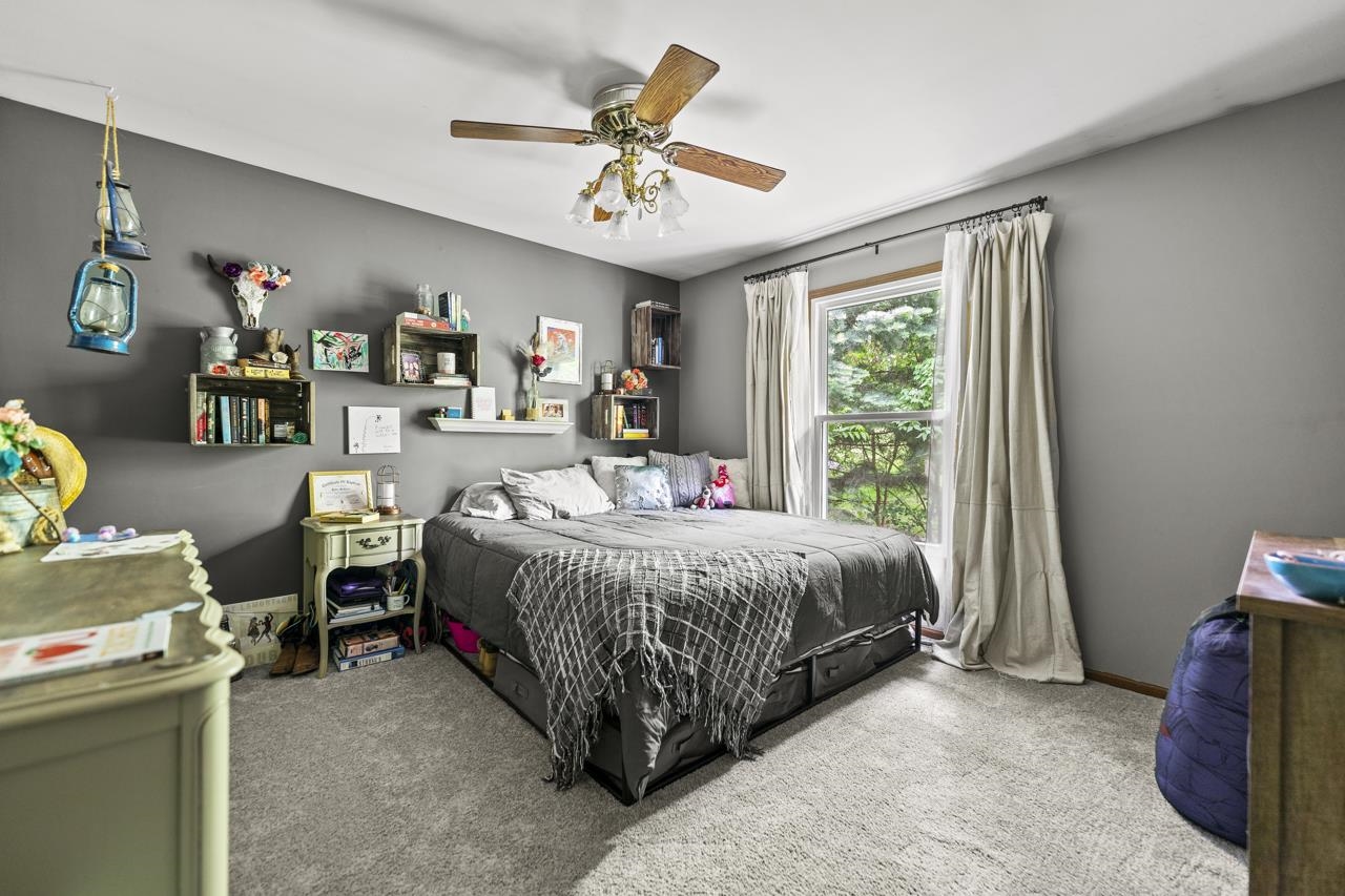 1084 Winborne Road Lake Summerset, IL 61019 - Photo 9 of 27 a spacious bedroom with a bed and a chandelier