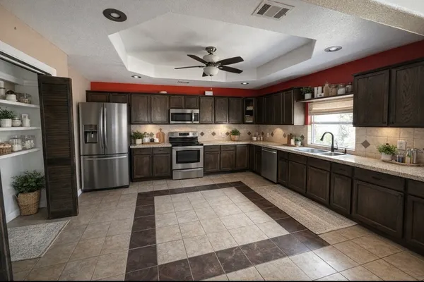 a kitchen with stainless steel appliances granite countertop a sink dishwasher stove top oven and refrigerator