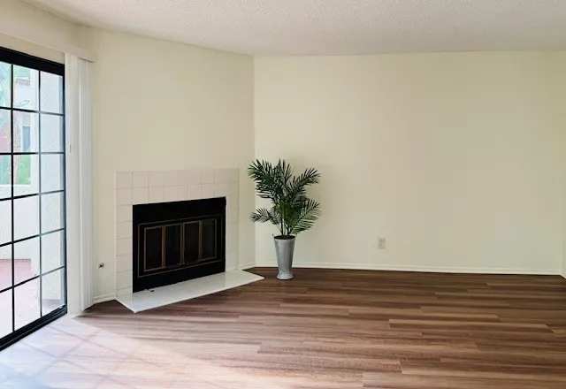 a view of a livingroom with wooden floor and a fireplace