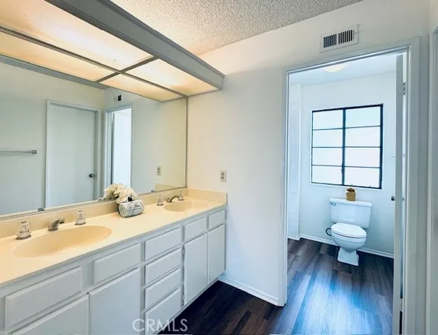 a spacious bathroom with a granite countertop sink toilet and a large mirror