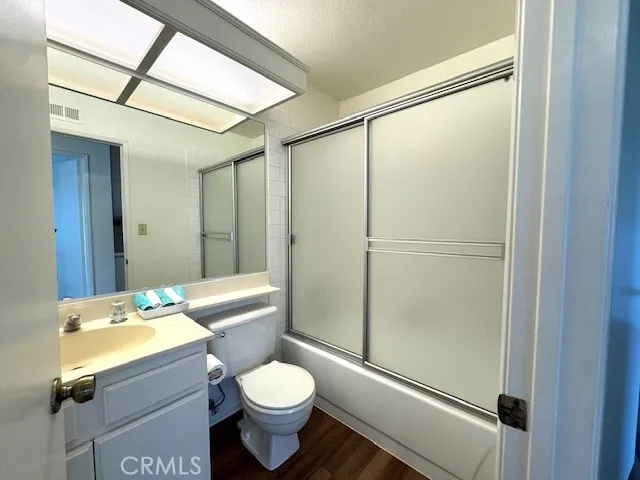 a bathroom with a granite countertop sink mirror vanity and toilet