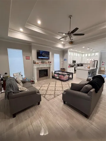 a living room with furniture kitchen view and a chandelier