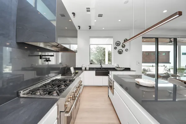 a large kitchen with stainless steel appliances granite countertop a lot of counter space and a sink