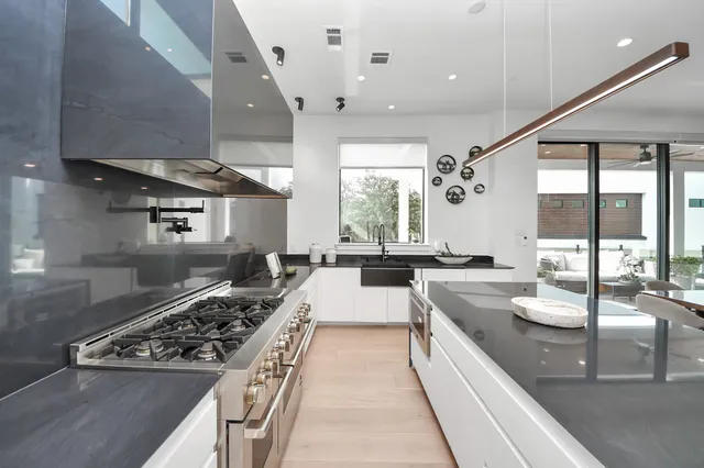 a large kitchen with stainless steel appliances granite countertop a lot of counter space and a sink