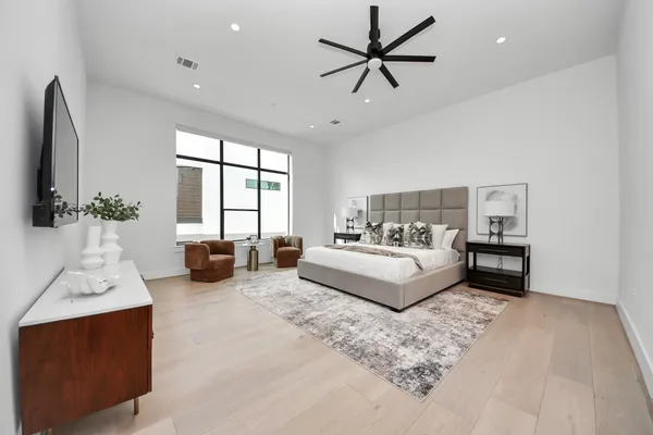 a living room with furniture ceiling fan and a flat screen tv
