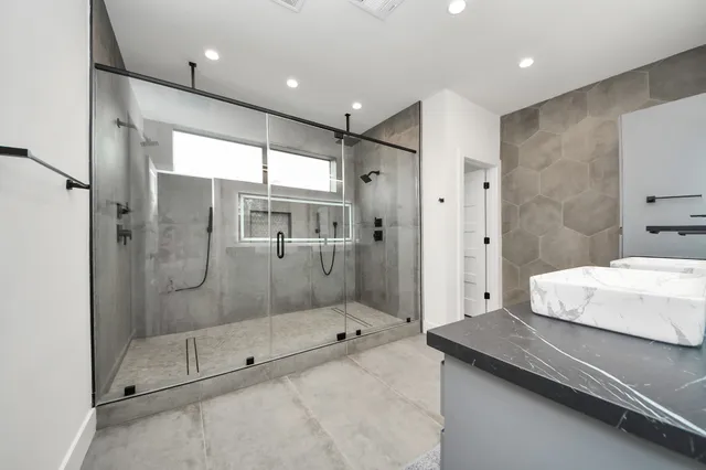 a bathroom with a shower and a sink a mirror