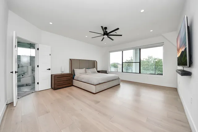 a bedroom with a large bed and a flat screen tv
