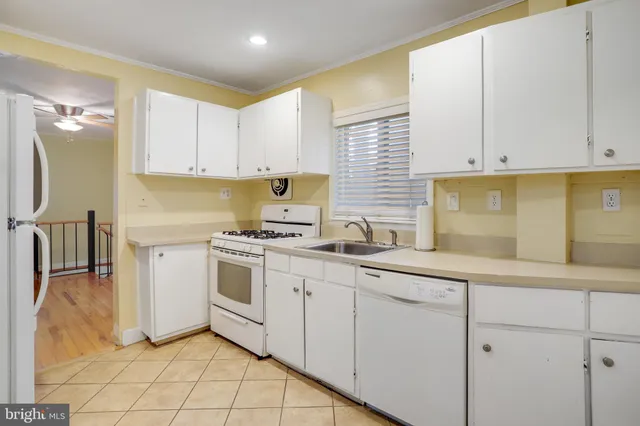 a kitchen with white cabinets and white appliances