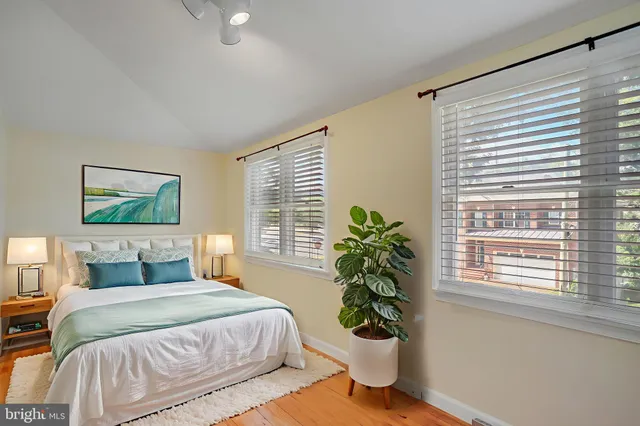 a bedroom with a large bed and a potted plant