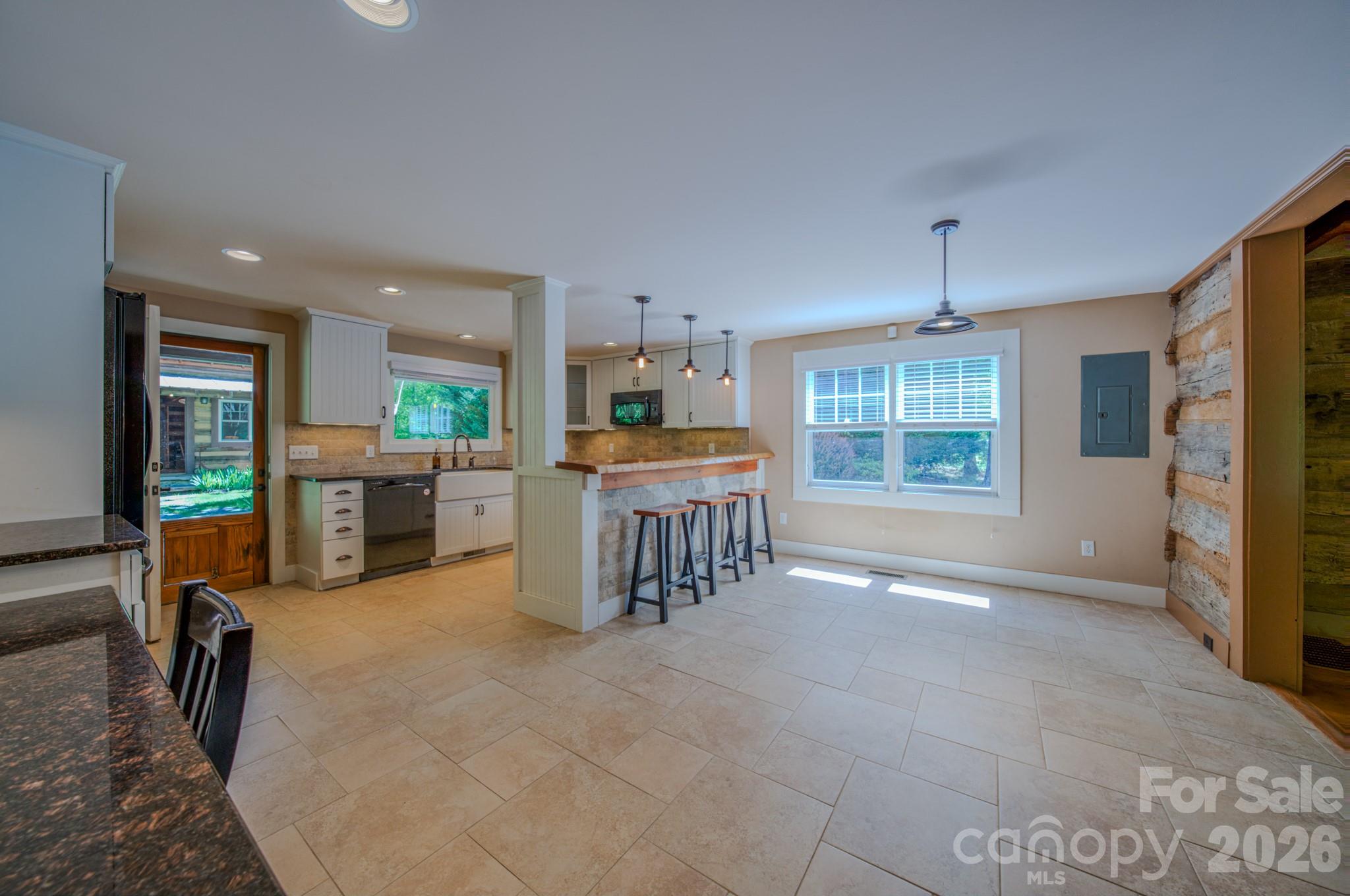 75 Old Gap Creek Road Fairview, NC 28730 - Photo 12 of 43 a open kitchen with stainless steel appliances granite countertop a stove top oven a sink a dining table and chairs with the wooden floor
