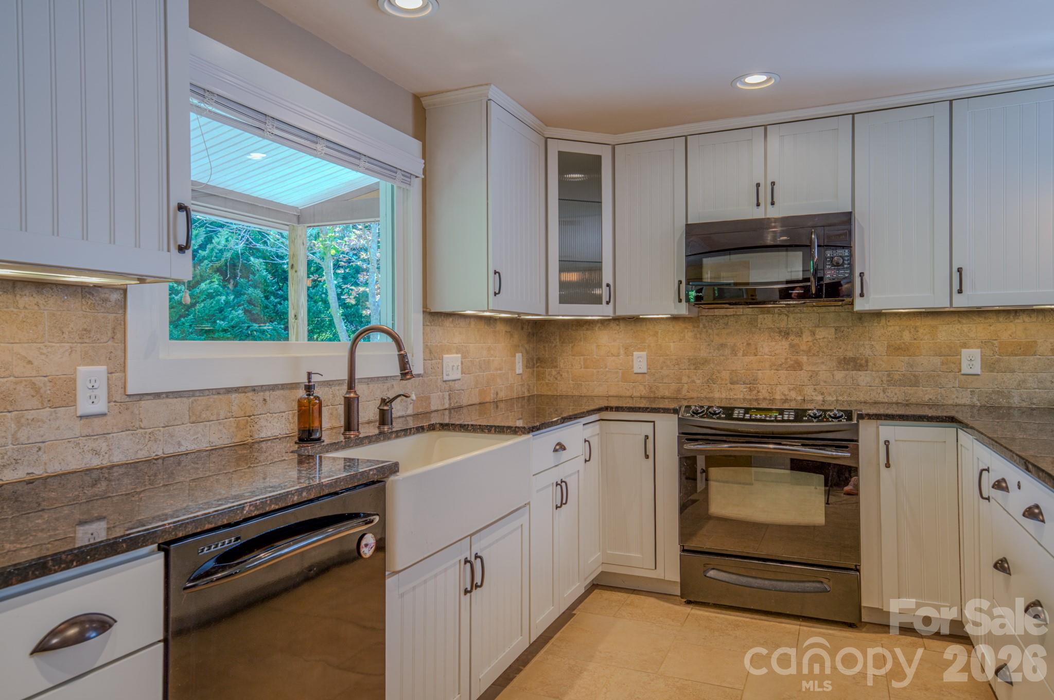 75 Old Gap Creek Road Fairview, NC 28730 - Photo 15 of 43 a kitchen with granite countertop white cabinets and stainless steel appliances