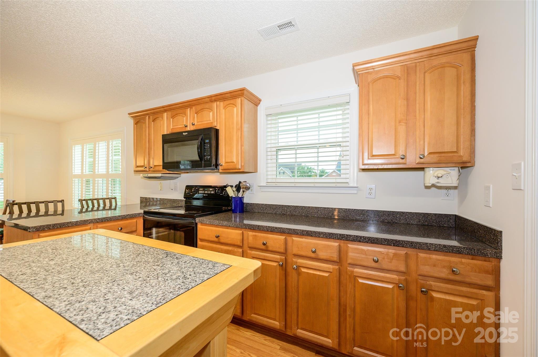 12617 Hill Pine Road Midland, NC 28107 - Photo 14 of 42 a kitchen with stainless steel appliances granite countertop a sink stove and microwave
