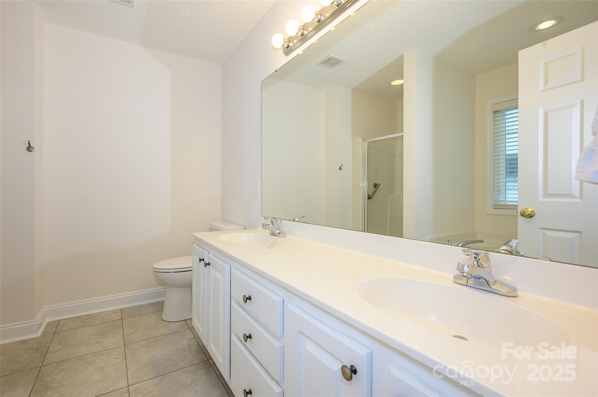 12617 Hill Pine Road Midland, NC 28107 - Photo 20 of 42 a spacious bathroom with a granite countertop sink mirror and toilet