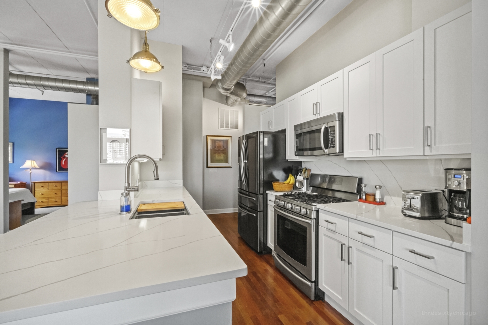 1301 West Madison Street, Unit 308 Chicago, IL 60607 - Photo 6 of 21 a kitchen with stainless steel appliances granite countertop a sink dishwasher stove and white cabinets with wooden floor