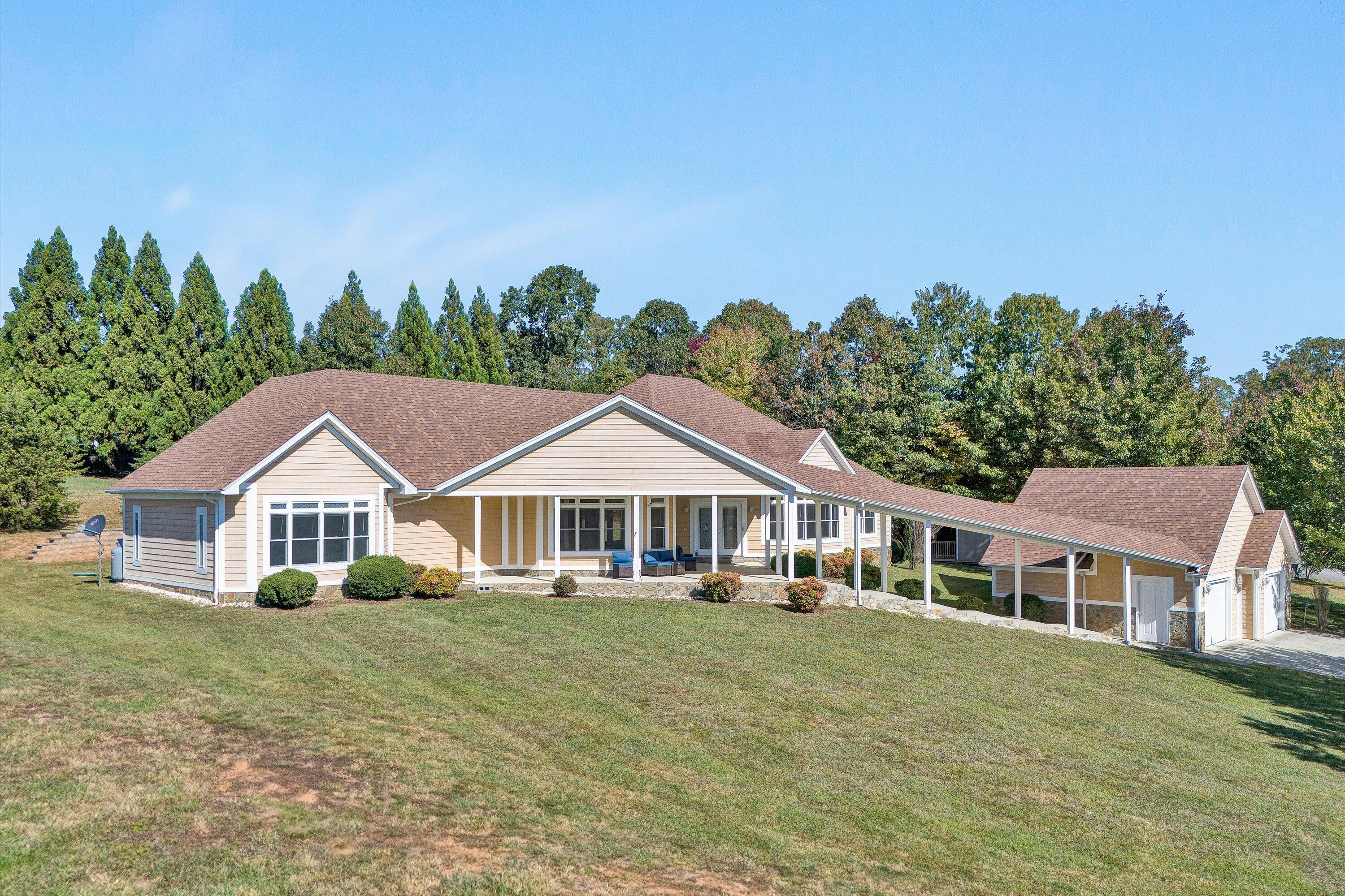 a front view of a house with a yard and trees