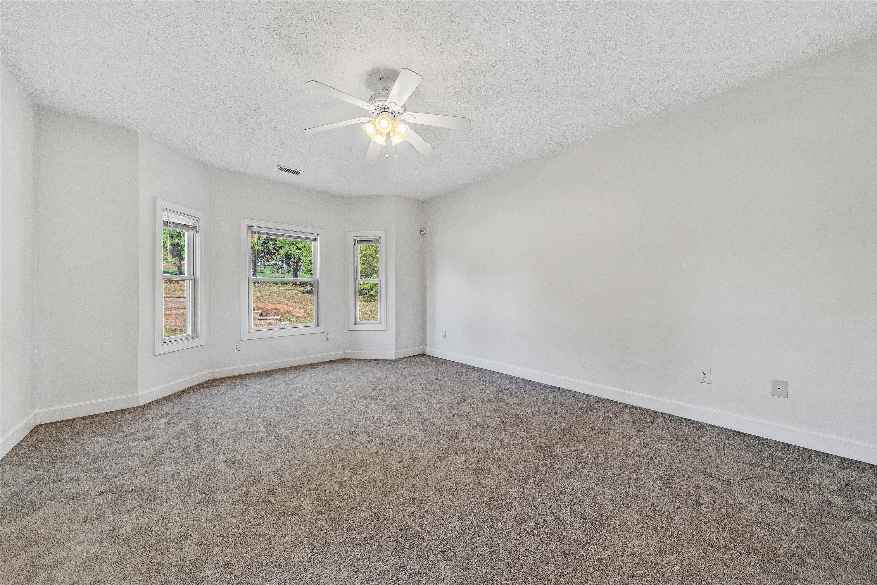537 Calypso Road Moneta, VA 24121 - Photo 35 of 55 an empty room with windows and chandelier fan