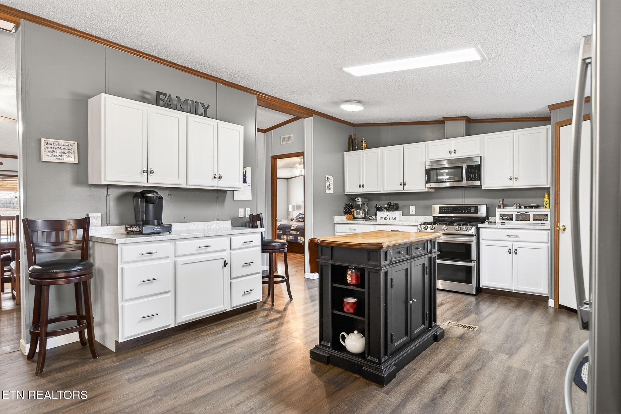 3773 Glade Creek Road Sparta, TN 38583 - Photo 5 of 59 a kitchen with stainless steel appliances white cabinets a sink a stove a refrigerator and island with wooden floors