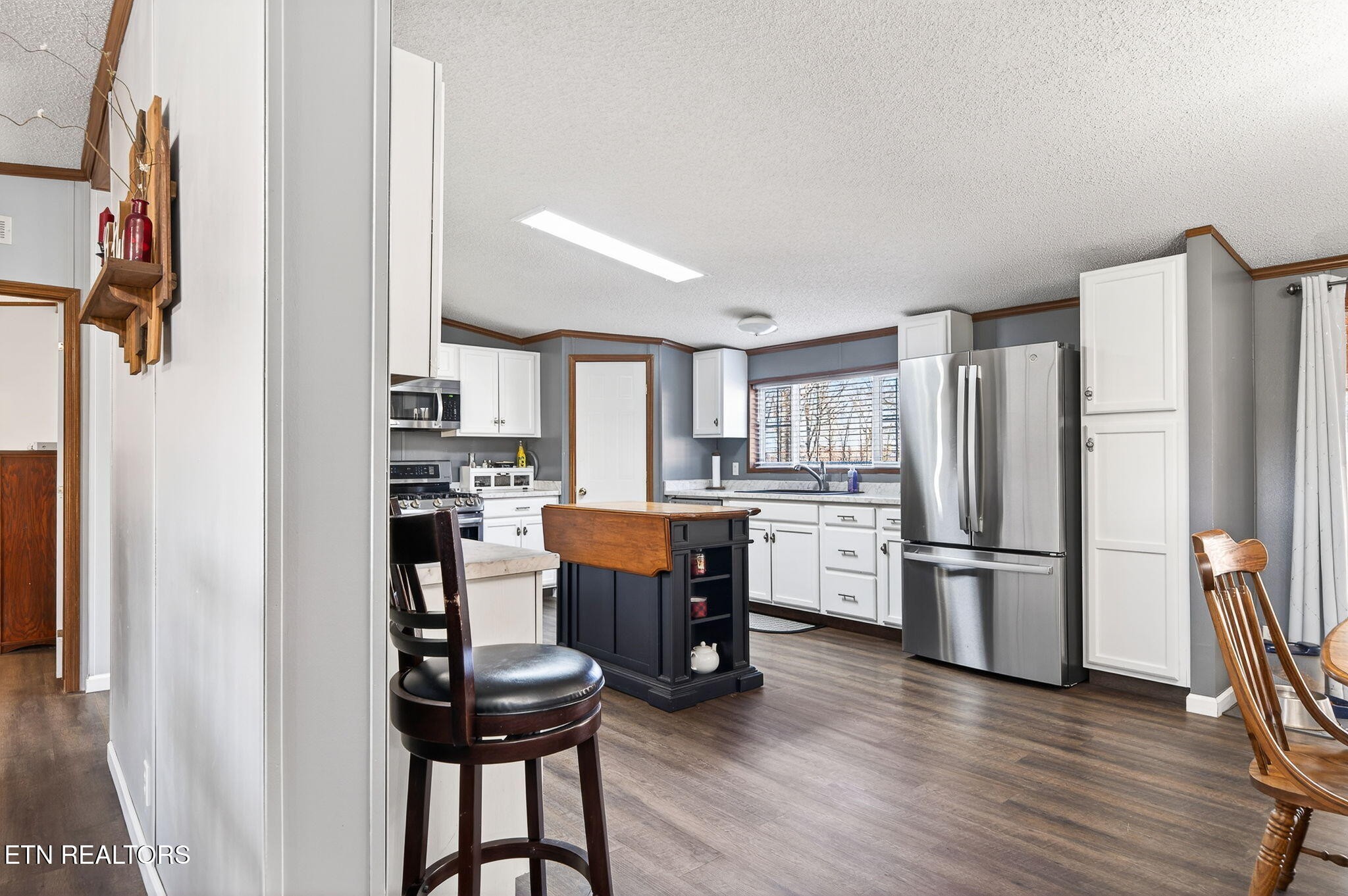 3773 Glade Creek Road Sparta, TN 38583 - Photo 6 of 59 a kitchen with stainless steel appliances a refrigerator a stove a dining table and chairs with wooden floor