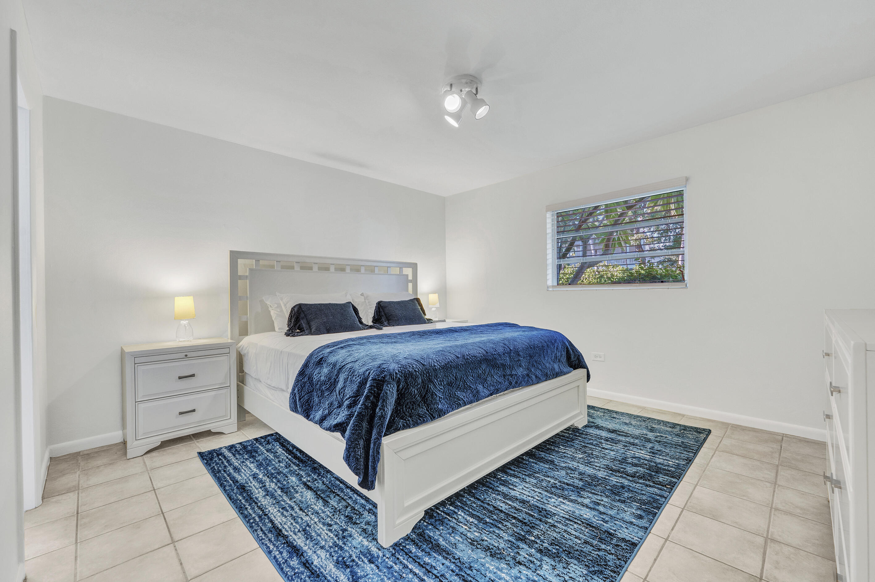 1129 Pebble Beach Lane, Unit 6 Marathon, FL 33050 - Photo 17 of 31 a bedroom with a large bed and a chandelier