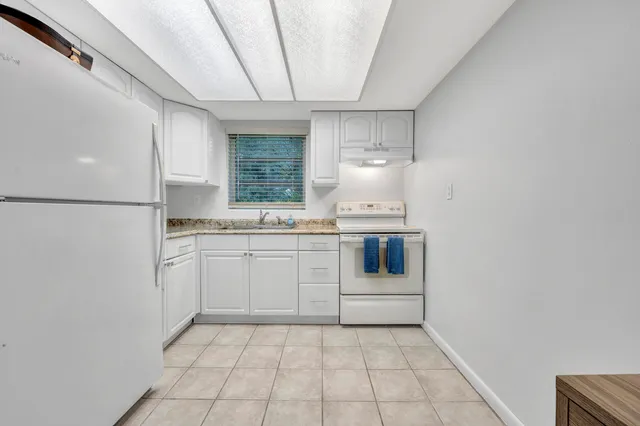 a kitchen with white cabinets and white appliances