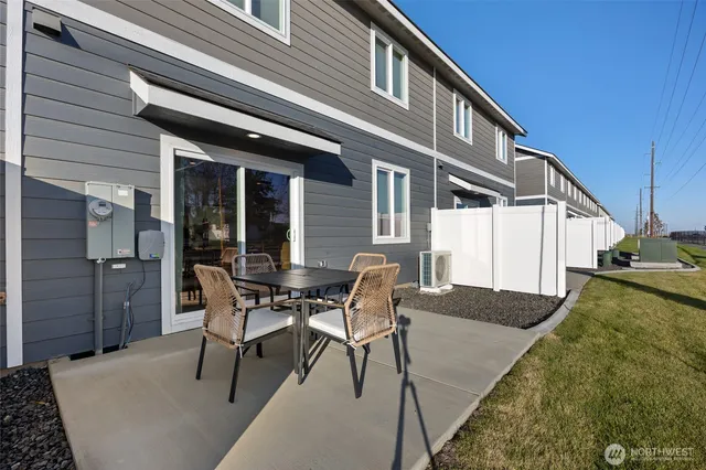 a patio with table and chairs and potted plants