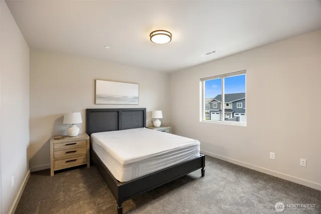 a large bed sitting in a bedroom next to a window