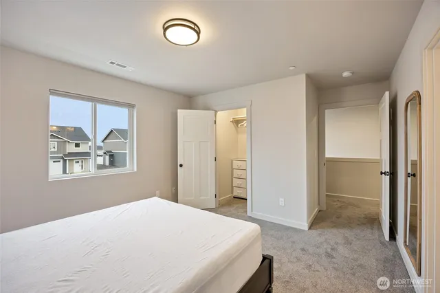 a bedroom with a bed and a painting on the wall