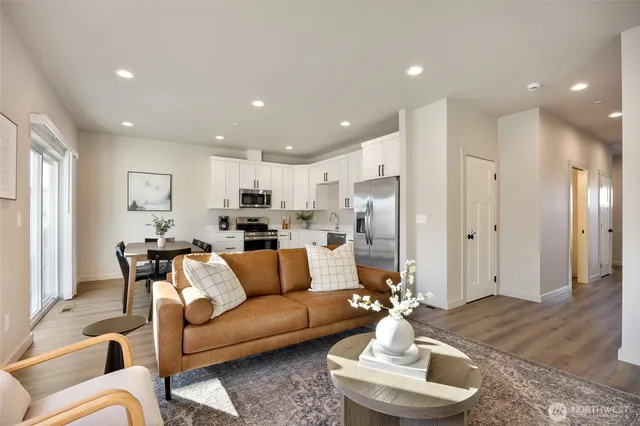 a living room with furniture kitchen and a chandelier