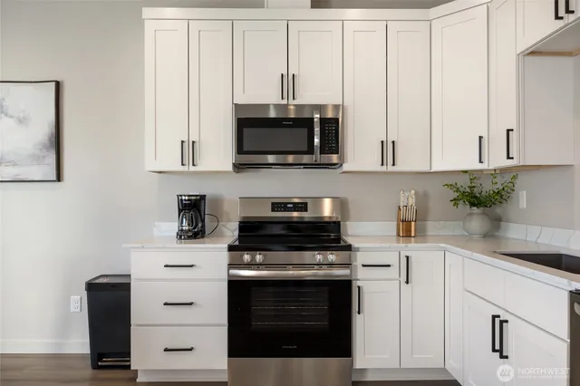 a kitchen with granite countertop white cabinets and stainless steel appliances
