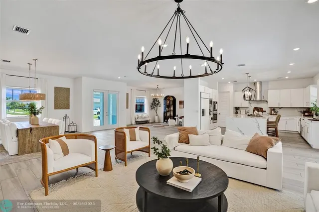 a living room with furniture a chandelier and a table