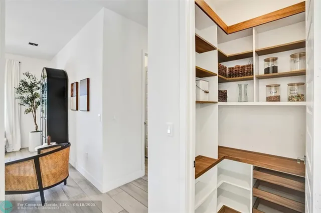 a view of walk in closet with clothes and shoes