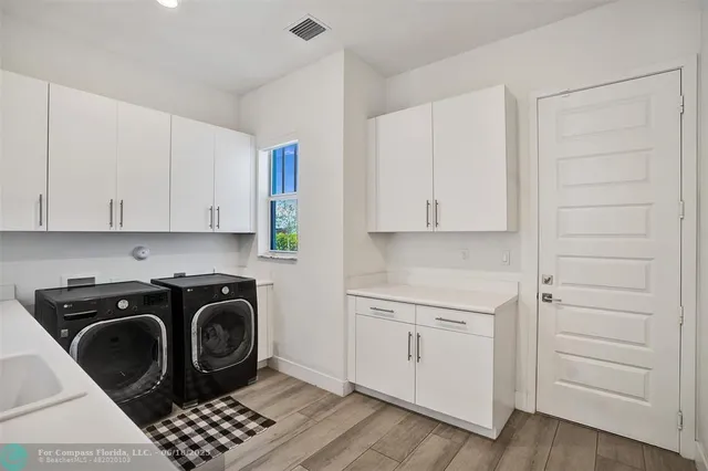 a utility room with cabinets washer and dryer