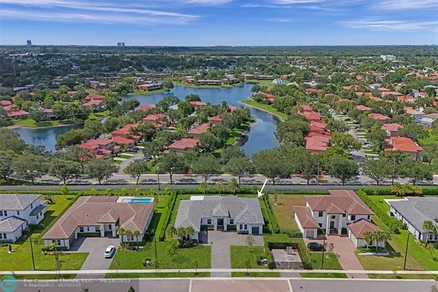 an aerial view of a residential houses with outdoor space and lake view