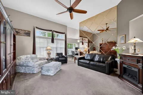 a living room with furniture ceiling fan and a window
