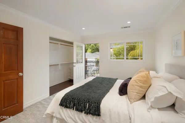 a front view of a house with a yard and potted plants