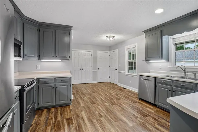 a kitchen with stainless steel appliances granite countertop a sink stove and refrigerator