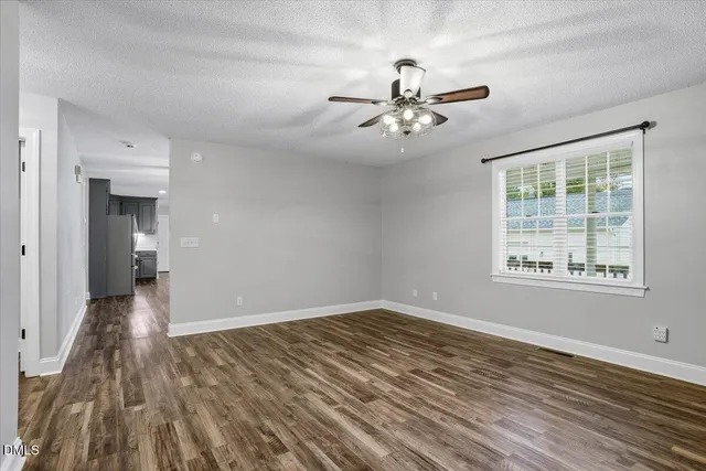 a view of an empty room with a fireplace and a window