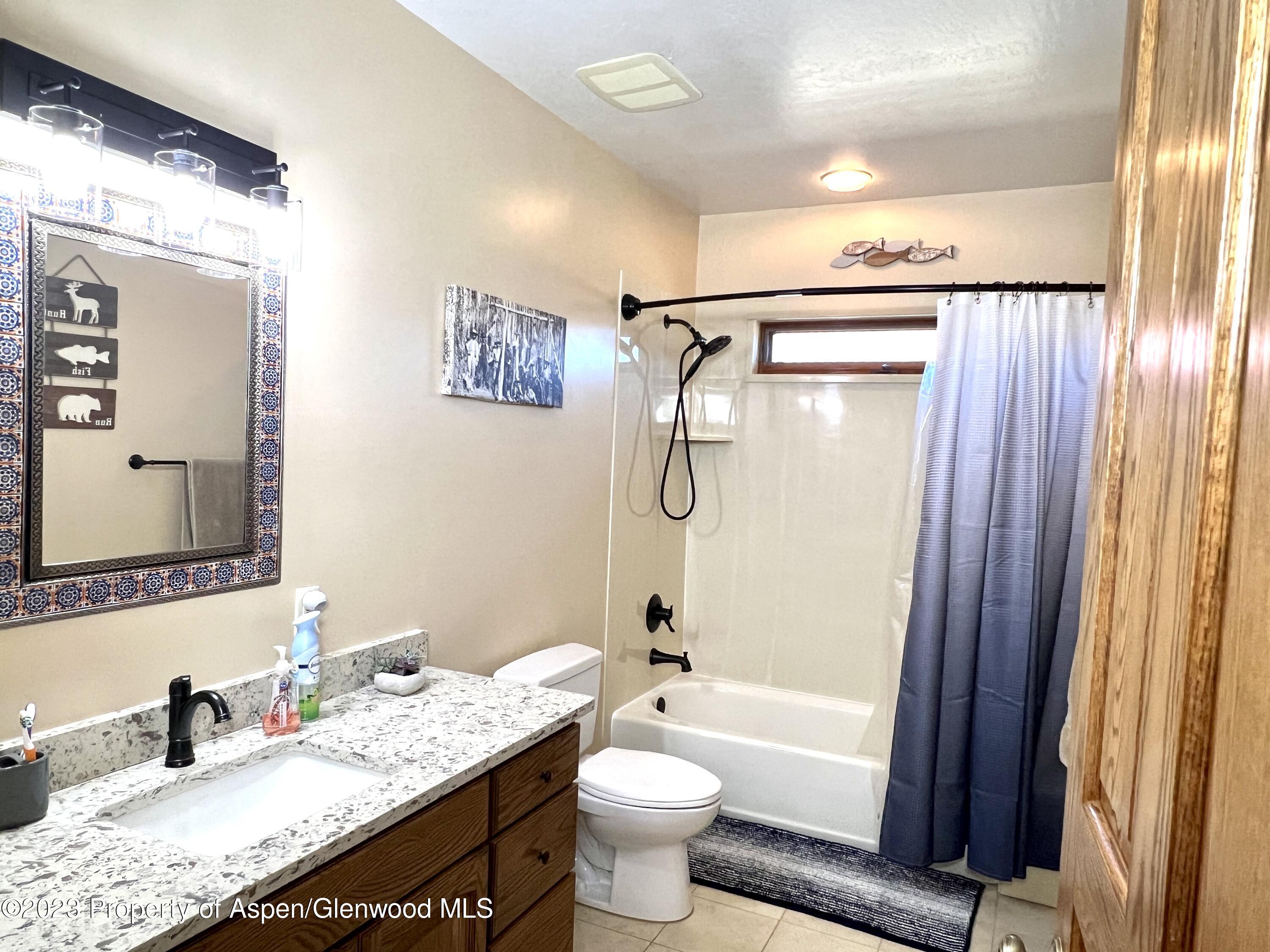 1007 Mesa Drive Rifle, CO 81650 - Photo 15 of 27 a bathroom with a granite countertop sink toilet and shower