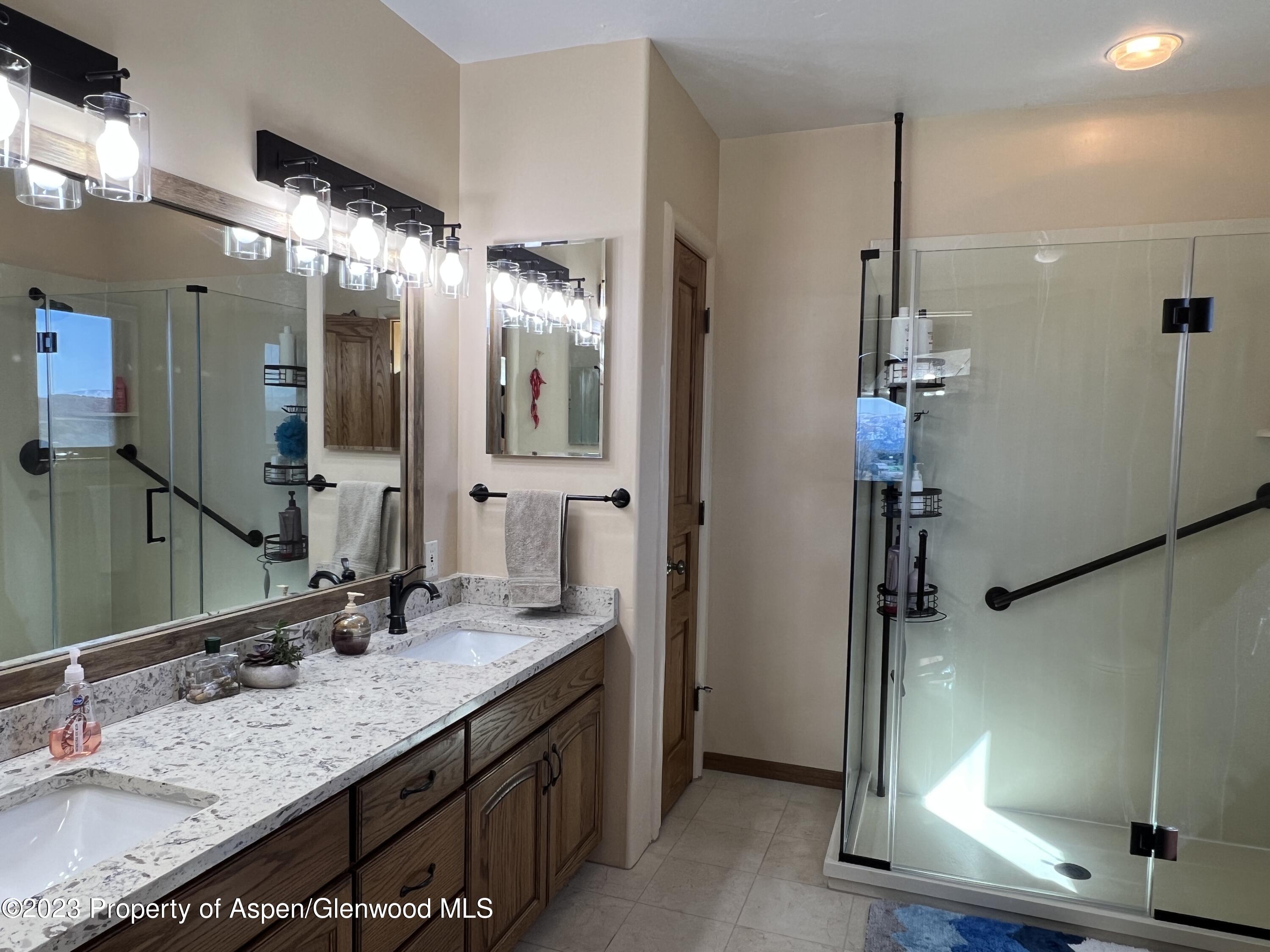 1007 Mesa Drive Rifle, CO 81650 - Photo 19 of 27 a bathroom with a granite countertop sink and a mirror