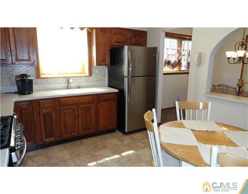 6 Harmon Road Edison, NJ 08837 - Photo 4 of 19 a kitchen with a table chairs refrigerator and microwave