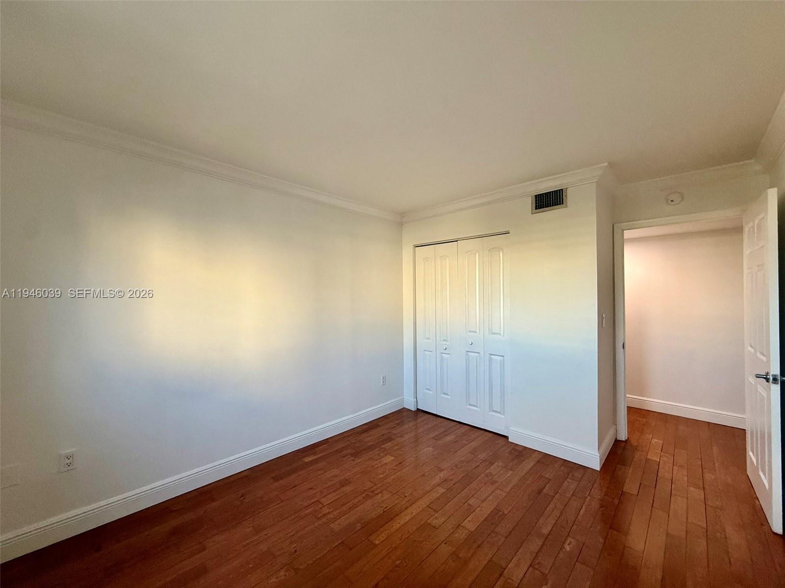 1605 Bay Road, Unit 407 Miami Beach, FL 33139 - Photo 20 of 31 a view of an empty room with wooden floor and closet